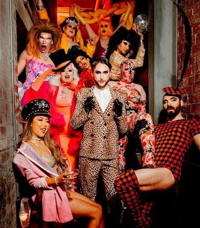 Group of people are standing on a set of stairs dressed up in extravagant costumes.