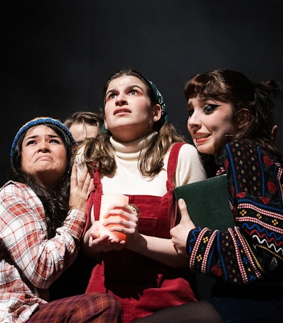 Charlie, Sam, and TJ stand huddled together in fear, with Satan's followers surrounding them. Charlie is holding a red candle, and Sam is holding the book they used to try to summon Santa.